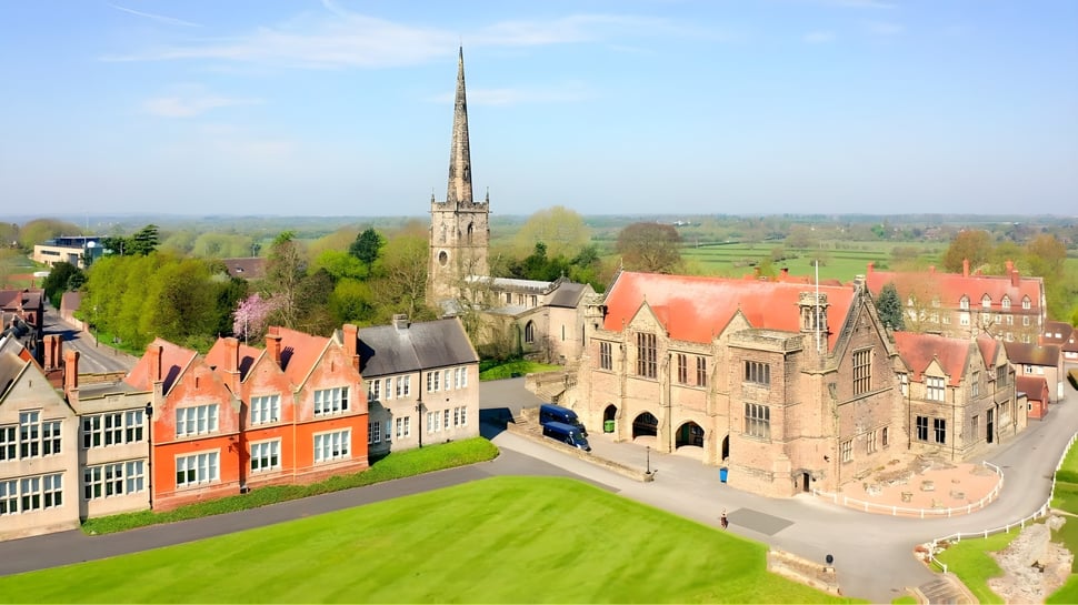 Vista de una ciudad medieval con edificios coloridos y una alta punta cerca de la Repton School.