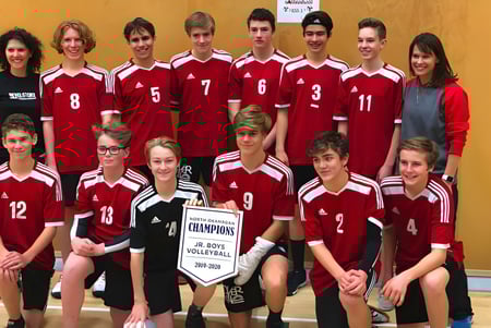 El equipo de voleibol de Revelstoke Secondary School posa con el trofeo del campeonato en el gimnasio.