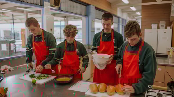 Cuatro estudiantes del Reynella East College preparan comida en una cocina comercial.