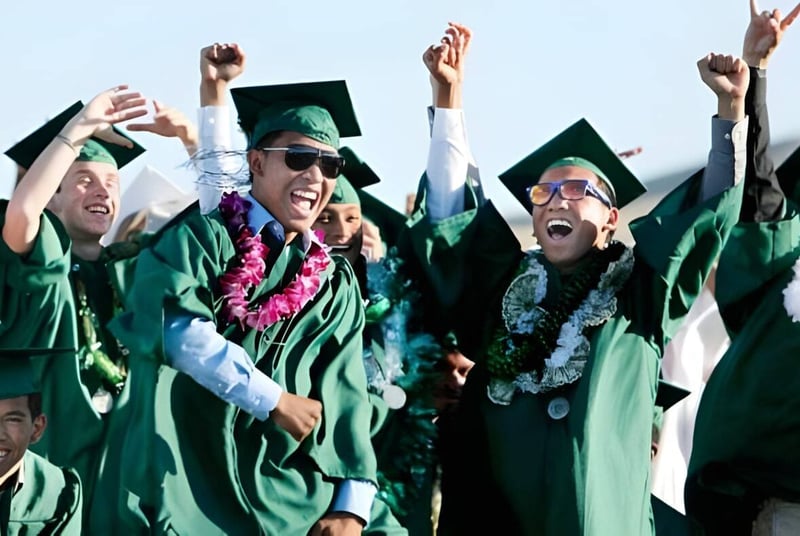 Un grupo de graduados de Ribet Academy celebra su ceremonia de graduación bajo un cielo azul claro.