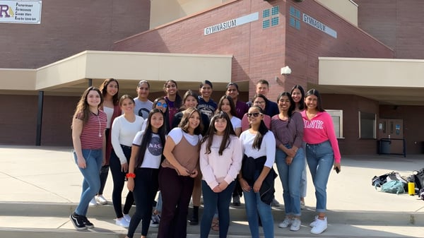 Un grupo de alumnas está frente a un edificio de ladrillo en el terreno de la Ridgeview High School.