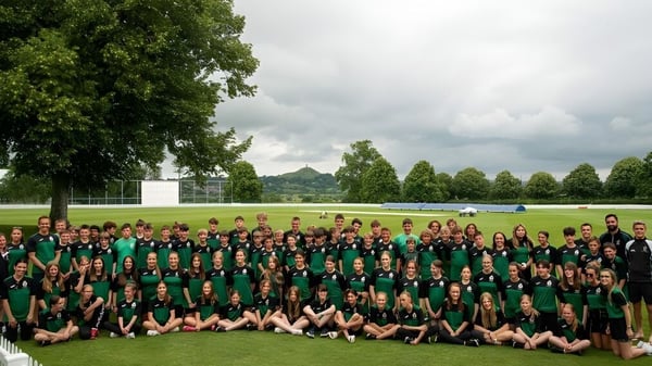 Un grupo de estudiantes de la Ringwood School se reúne en una pradera con árboles al fondo.