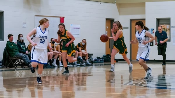 Estudiantes de la Robert Thirsk High School juegan un partido de baloncesto en el gimnasio.