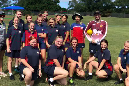 Un grupo de jóvenes atletas de la Rochedale State High School posan juntas en un campo de hierba.