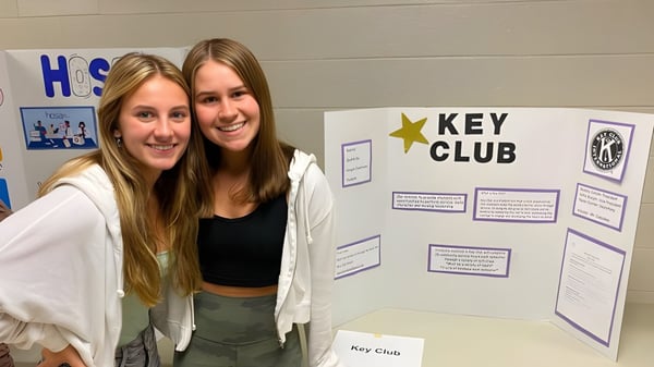Dos estudiantes están frente al tablón de anuncios del Key Club en el campus de Rochester Community Schools.