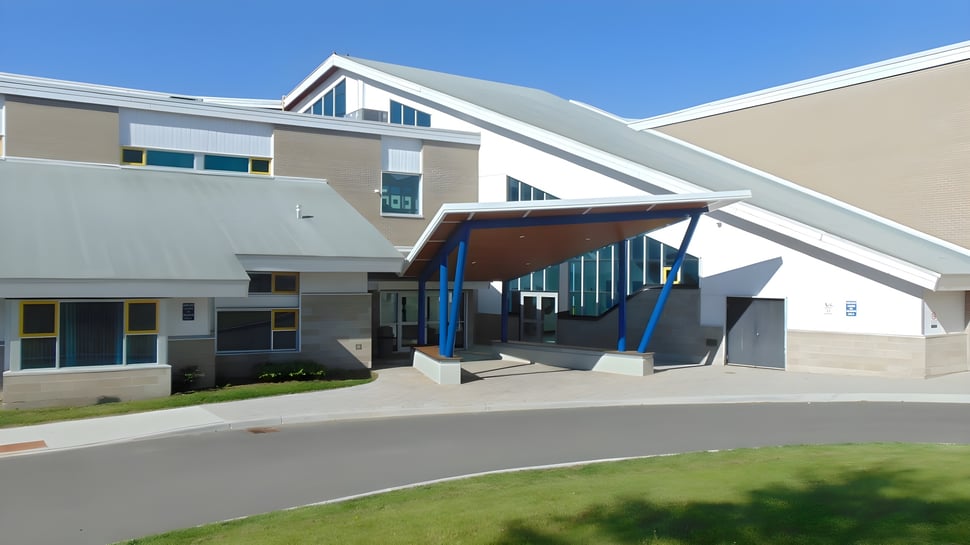 El moderno edificio escolar de la Rockland District High School con entrada cubierta y grandes ventanas.
