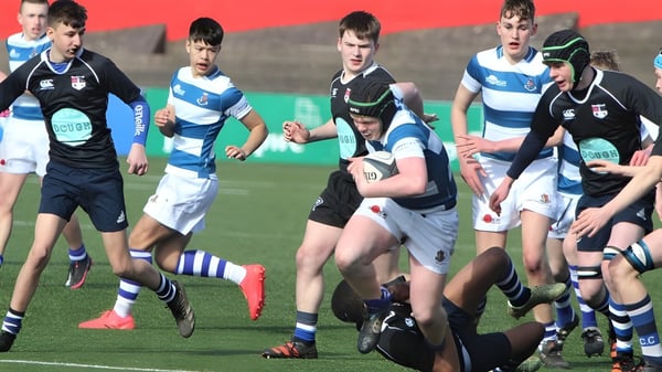 Un grupo de jugadores de rugby juega un intenso partido en el campo deportivo del Rockwell College.