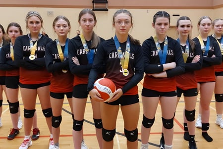 Un grupo de jugadoras de voleibol está juntas en el gimnasio de la Roncalli Central High.