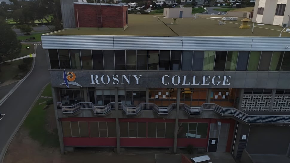El edificio de varios pisos de Rosny College está rodeado de una superficie de césped y otros edificios.