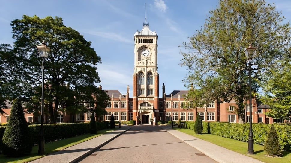 Se puede ver el histórico edificio principal de la Royal Masonic School for Girls con un alto reloj en el cuidado campus.