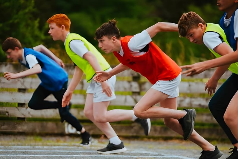 Un grupo de jóvenes atletas corre en la pista en el terreno de la Royal School Dungannon.