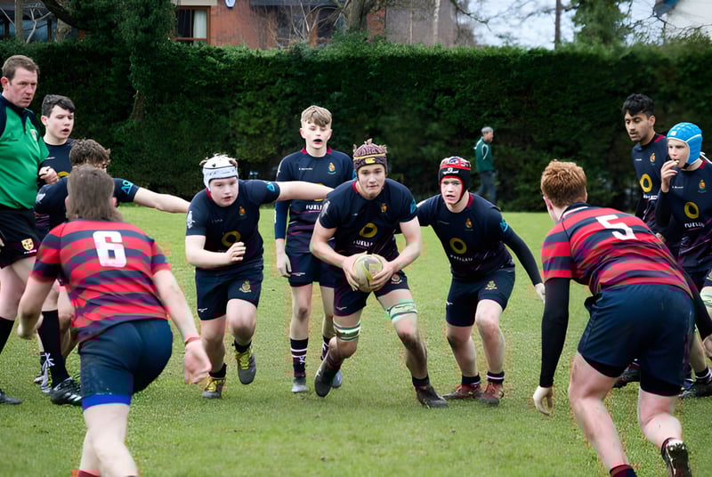 Un grupo de estudiantes jugando al rugby en el campo de la Royal School.