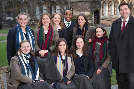Un grupo de estudiantes de la Rugby School posan frente a un edificio histórico con características góticas.