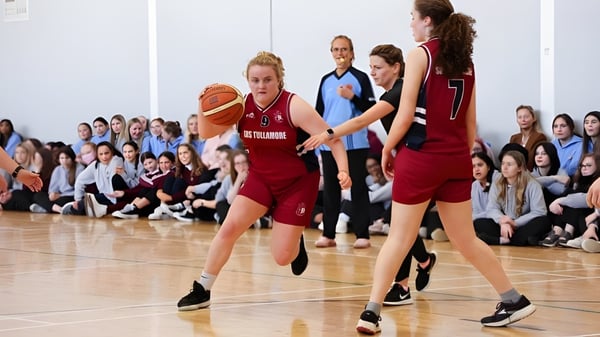Alumnas juegan un partido de baloncesto en el gimnasio de la Sacred Heart Secondary School en Tullamore frente a espectadores.
