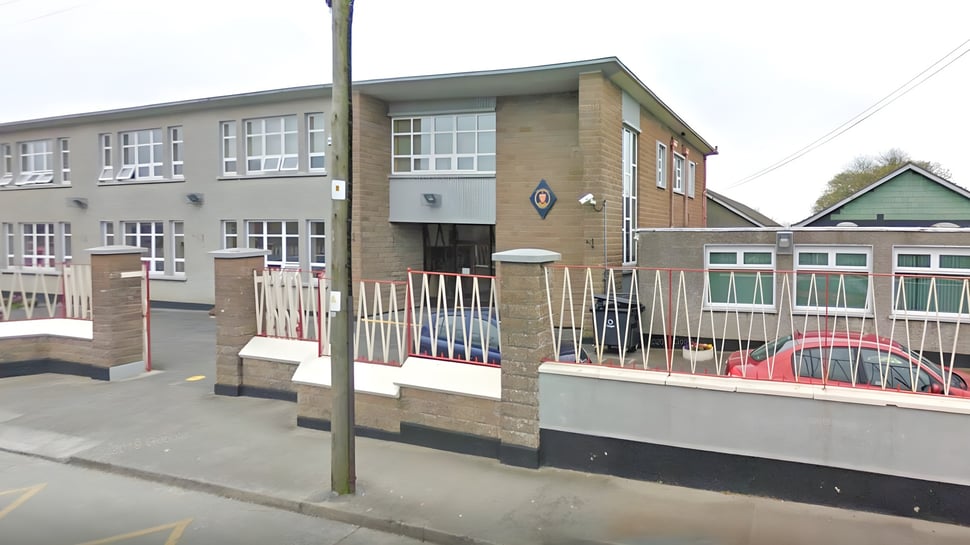 El edificio de ladrillo de varios pisos de la Sacred Heart Secondary School en Drogheda con grandes ventanas y un área cercada en el frente.