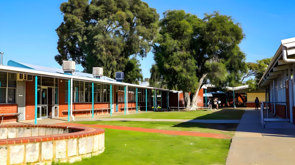 El bien cuidado área externa de la Safety Bay Senior High School muestra varios edificios y un camino pavimentado a través de instalaciones verdes.