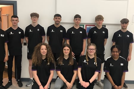Un grupo de estudiantes con camisetas negras está reunido en un aula del Salisbury Sixth Form College.