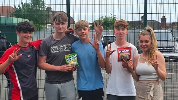 Un grupo de estudiantes está frente a una valla de alambre en el terreno del Salisbury Sixth Form College.