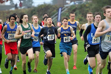 Un grupo de estudiantes de la Sands Secondary School participa en una carrera de campo a través en un campo.