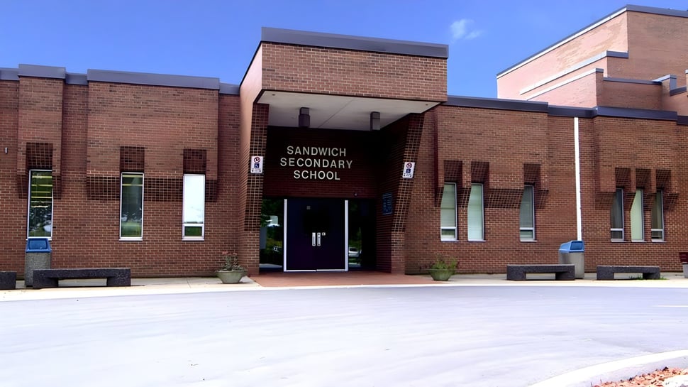 El edificio de ladrillo de la Sandwich Secondary School bajo un cielo azul claro.