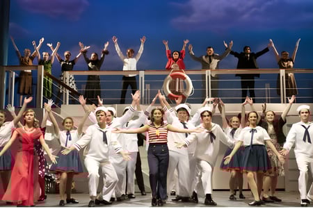 Un grupo de estudiantes del Schull Community College está en varios disfraces en un escenario bajo un cielo nublado.