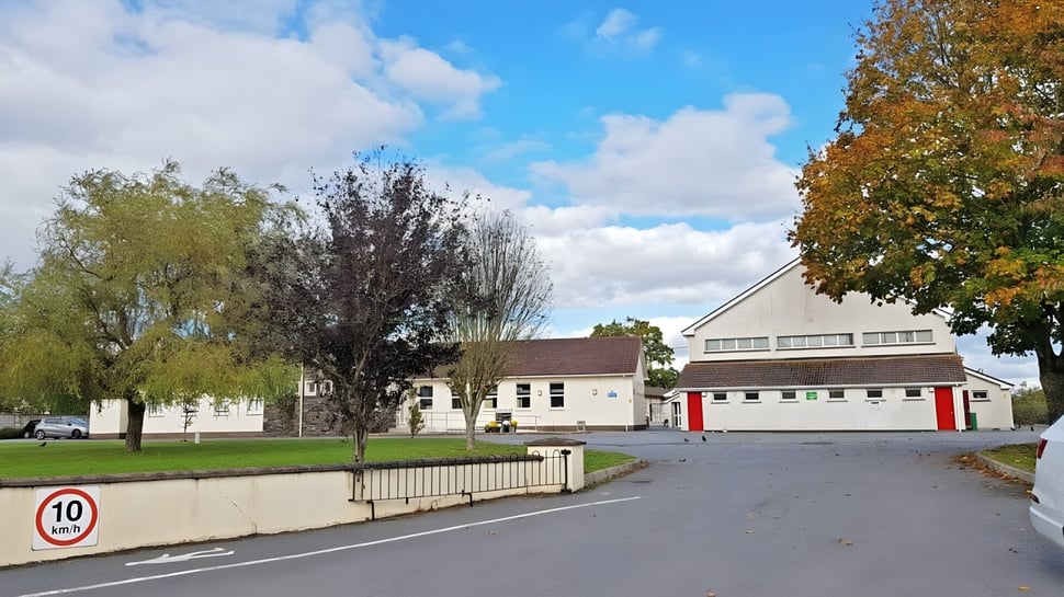 Vista de una zona residencial con edificios antiguos y nuevos y árboles otoñales cerca de Scoil Aireagail.