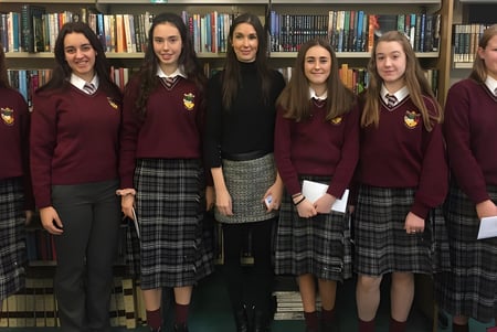 Un grupo de alumnas de Scoil Dara está frente a una estantería llena de libros.