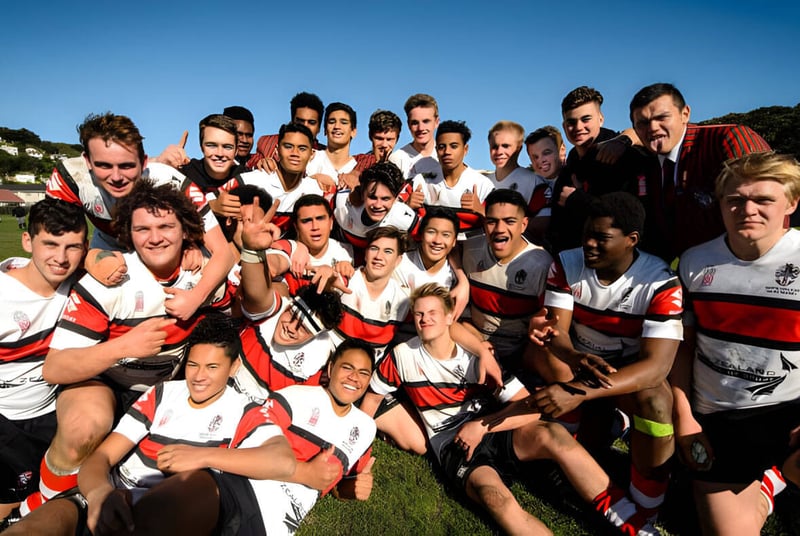 Un grupo de estudiantes del Scots College posan juntos en un campo de hierba bajo un cielo despejado.