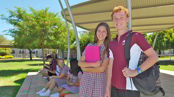 Un grupo de estudiantes está en un prado frente a un edificio en el campus del Seaford Secondary College.