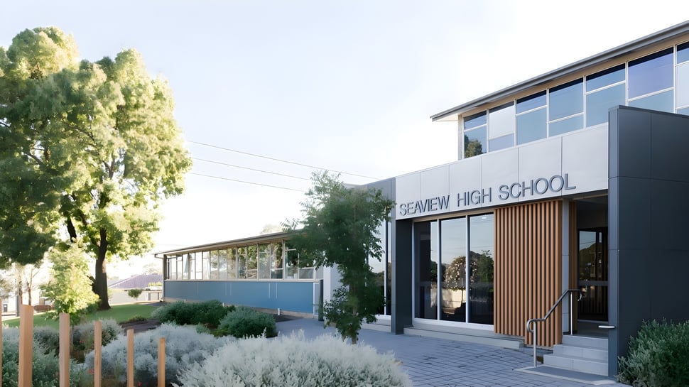 El moderno edificio escolar de la Seaview High School está rodeado de mucho verde y se ve bajo un cielo azul.