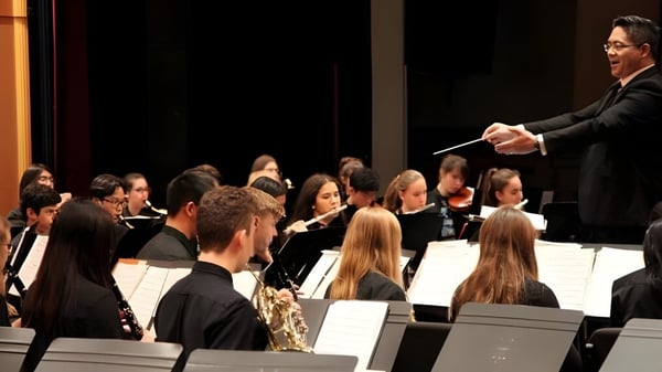 Un director dirige una orquesta durante una actuación en el campus de la Semiahmoo Secondary School.