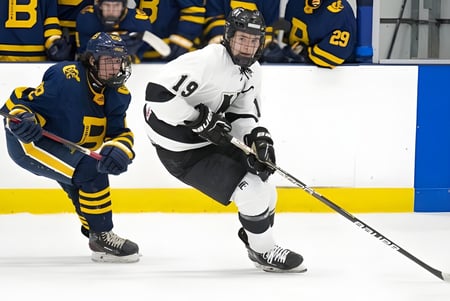 Dos jugadores de hockey sobre hielo luchan en el hielo por el puck en la superficie de juego de la Seycove Secondary School.