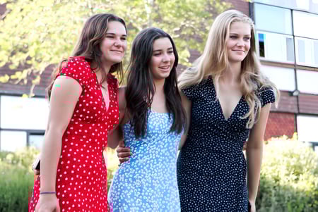Tres jóvenes mujeres están juntas frente a un edificio en el campus del Shebbear College.