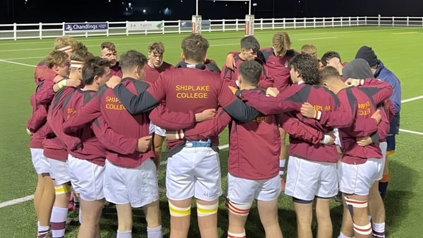 Un grupo de estudiantes se encuentra junto en el campo de deportes del Shiplake College.