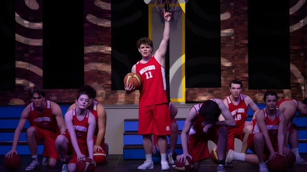 Los jugadores de baloncesto de Shirley Boys' High School en camisetas rojas durante un partido en la cancha de baloncesto.