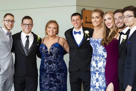 Un grupo de personas vestidas formalmente en un evento en el campus de la Shrewsbury School.