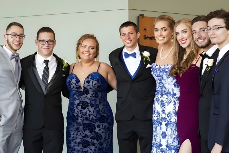 Un grupo de personas vestidas formalmente en un evento en el campus de la Shrewsbury School.