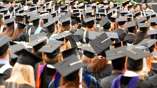 Graduados y graduadas de la Sir Charles Tupper Secondary School llevan togas negras y se reúnen para la ceremonia de graduación.