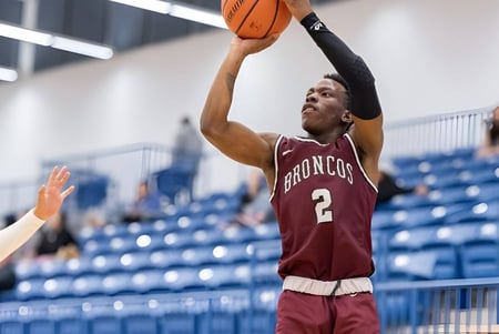 Un jugador de baloncesto de la Sir Frederick Banting Secondary School salta y lanza la pelota hacia la canasta en la cancha de baloncesto.