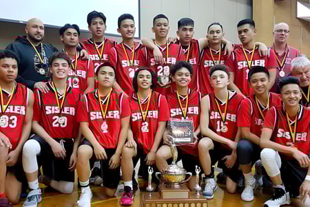 El equipo de baloncesto de la Sisler High School posa con un trofeo en el vestuario.