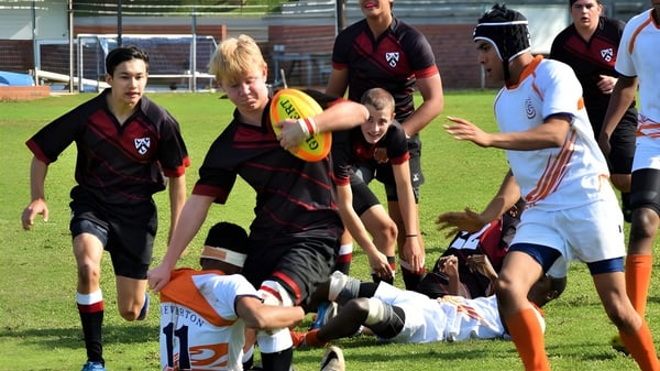 Estudiantes del Slindon College participan en una actividad deportiva en un campo.