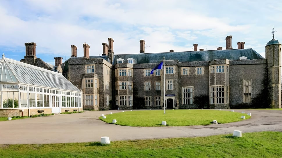 La histórica mansión en el terreno del Slindon College está rodeada de césped bien cuidado y paisaje verde.