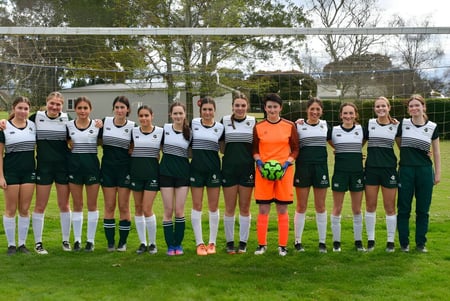 Un grupo de jóvenes futbolistas se encuentra en el campo de deportes del Solway College.