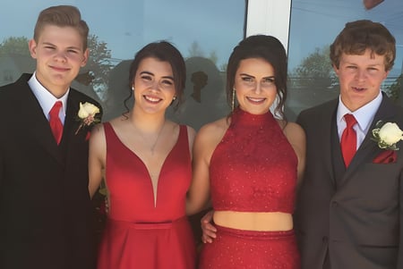 Cuatro estudiantes de la Souris Regional School están juntos en ropa festiva durante un evento escolar especial.