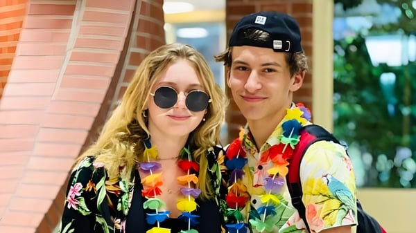 Dos personas están frente a un edificio de ladrillo de la South Grenville District High School.