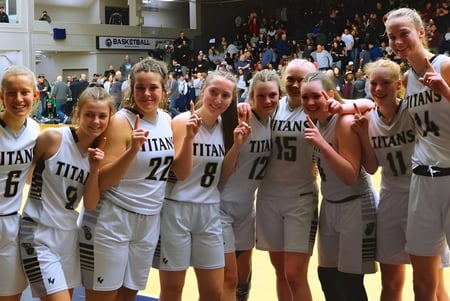 Un grupo de jóvenes jugadoras de baloncesto de la South Kamloops Secondary School está reunido en el gimnasio.