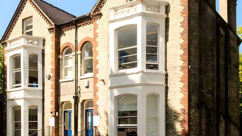 El edificio de ladrillo de varios pisos con ventanas decoradas se encuentra en el campus del St. Andrew’s College en Cambridge.