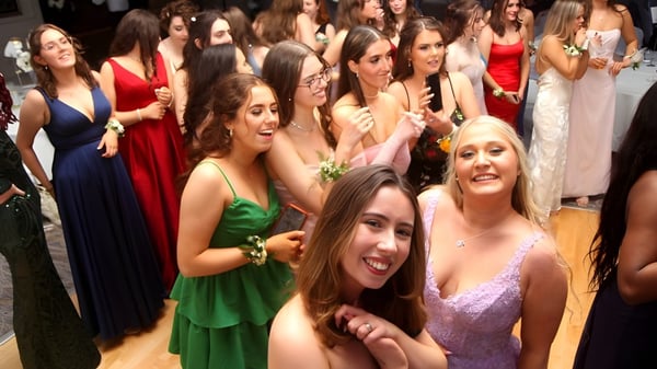 Un grupo de jóvenes mujeres en ropa formal en un evento nocturno en el campus de St. Angela’s College.