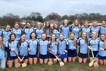 Un grupo de jóvenes deportistas en uniformes azul claro está en un campo en St. Brigid's College.