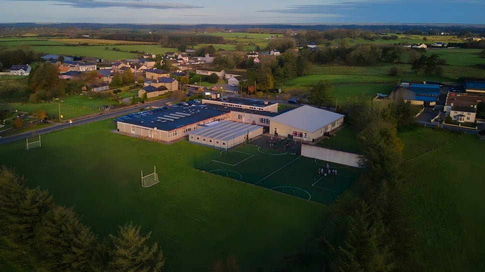 El terreno deportivo de St. Cuan’s College se encuentra al borde de un pueblo verde con colinas y bosques de fondo.